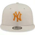 gorra-plana-beige-snapback-con-logo-naranja-9fifty-league-essential-de-new-york-yankees-mlb-de-new-era
